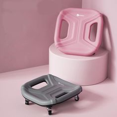 a pink chair sitting on top of a white stool next to a gray and grey object