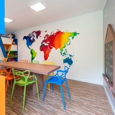 a dining room with colorful chairs and a map on the wall