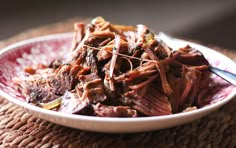 a bowl filled with shredded meat on top of a table