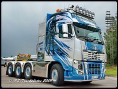 a blue and white semi truck parked in a parking lot