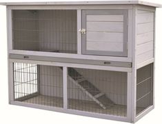 a large white and grey caged animal house with stairs on the outside, open doors