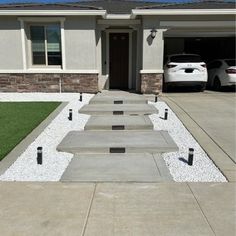 concrete steps lead up to the front door of a house with cars parked in the driveway