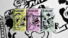 three cans of fuel up are lined up against a black and white wall with graffiti on it