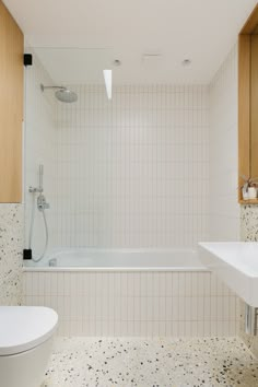 a bathroom with a tub, sink and toilet