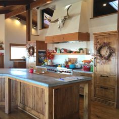 a large kitchen with wooden cabinets and an island in the center, is decorated with deer heads