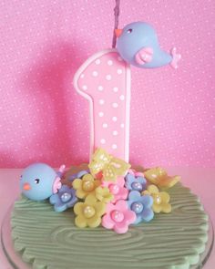 a pink and blue birthday cake with two little birds on it's number one