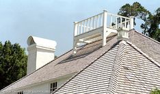 the top of a house with a white balcony