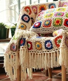 a colorful crocheted chair with fringes on it