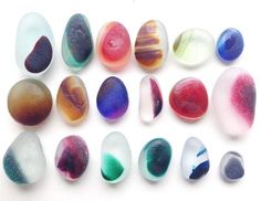 several different colored glass pebbles on a white surface