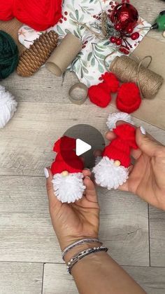 someone is making christmas decorations out of yarn and wool balls on the floor with their hands