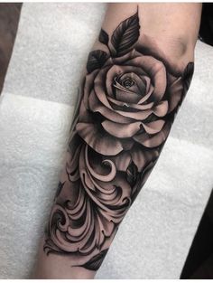 a black and white rose tattoo on the arm