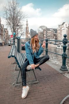 a woman sitting on top of a bench next to a bike