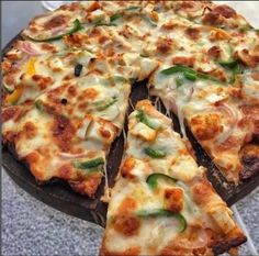 there is a pizza with many toppings on the plate and one slice missing from it