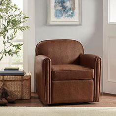 a living room with a brown leather chair next to a basket and potted plant