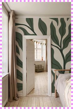 an open door leading to a bedroom with green leaves painted on the walls and floor