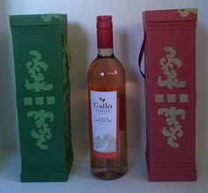 a bottle of wine sitting next to two boxes with designs on the top and bottom