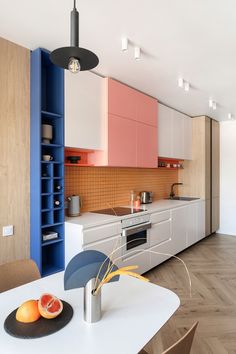 an image of a kitchen setting with oranges on the counter and blue cabinets in the background