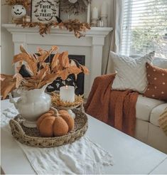 a living room filled with furniture and a fire place covered in pumpkins on top of a table