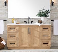 a bathroom vanity with two sinks and towels hanging on the wall next to each other