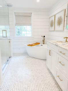 a bathroom with white walls and flooring has a large bathtub in the middle