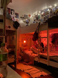 two bunk beds in a dorm room with posters on the wall and lights above them