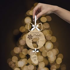 a hand is holding a wooden ornament with a snowflake on it