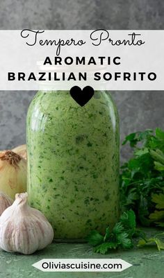 a jar filled with green pesto next to garlic and parsley