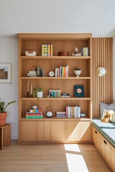 a bookshelf filled with lots of books in a living room next to a window