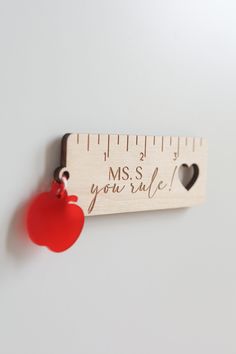 a wooden ruler with a red heart hanging from it's side and the words mss you're true