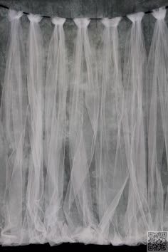 three white veils are hanging from the ceiling in front of a black and white background