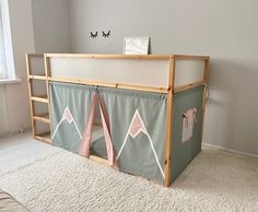 a child's bed with a tent on the top and ladder to the bottom