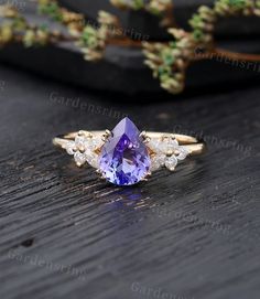 an amethorate and diamond ring on top of a wooden table