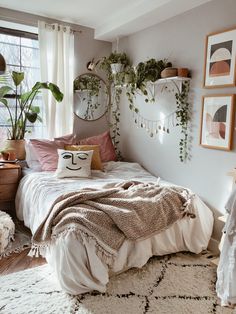 the bedroom is decorated with plants and pictures on the wall, along with a bed