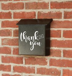 a brick wall with a sign on it that says thank you written in white ink