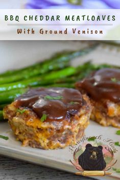 two meatloafs with gravy and asparagus on a plate