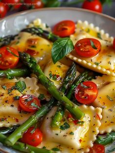 pasta with asparagus, tomatoes and parmesan cheese in a white bowl