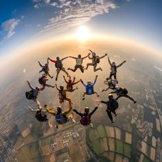 a group of people jumping in the air with their arms spread out and feet apart