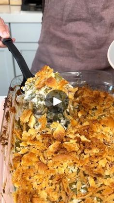 a person holding a spoon in a casserole dish