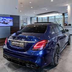 a blue car is parked in a showroom