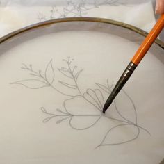 a person is drawing flowers on a plate