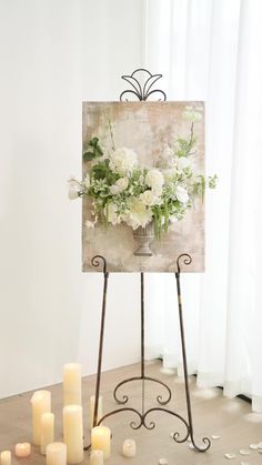 an easel with flowers and candles on it