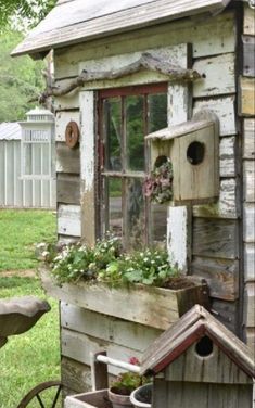 an old wooden house with flowers in the window