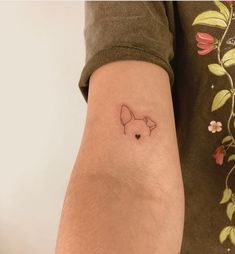 a small dog tattoo on the left arm