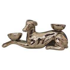 a golden dog figurine with a bowl on it's back and legs