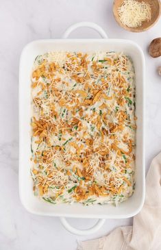 a casserole dish is topped with cheese, green onions and parmesan