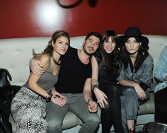 four people sitting on a couch posing for the camera