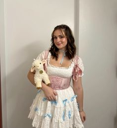 a woman in a dress holding a stuffed animal