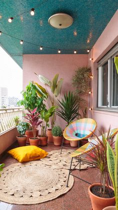 a balcony with potted plants on the floor and round rugs in front of it