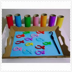 a tray with scissors and paper on top of it next to some colored crayons