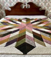 a bed with a quilt on top of it